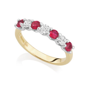 An 18ct gold and platinum seven stone ruby and diamond half eternity ring, belonging to H. L. Brown's Volante collection.