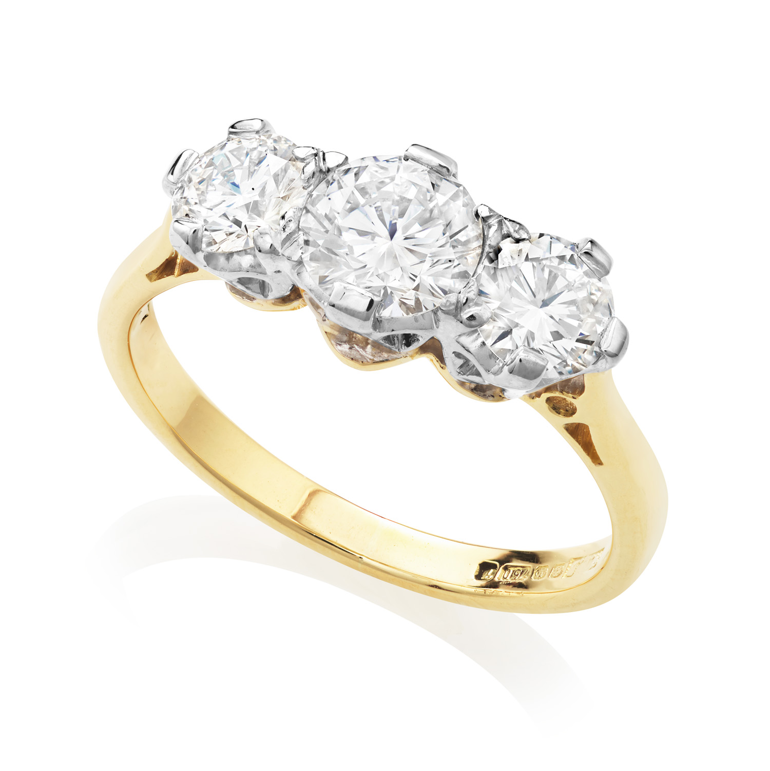 An 18ct yellow and white gold three stone ring with traditional style round brilliant cut diamonds. Hallmarked Sheffield 1993.