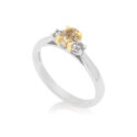 Platinum oval yellow diamond and brilliant cut diamond three stone ring with an 18ct yellow gold claw setting.