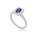 An 18ct white gold oval shaped sapphire and diamond set cluster ring with diamond set shoulders.