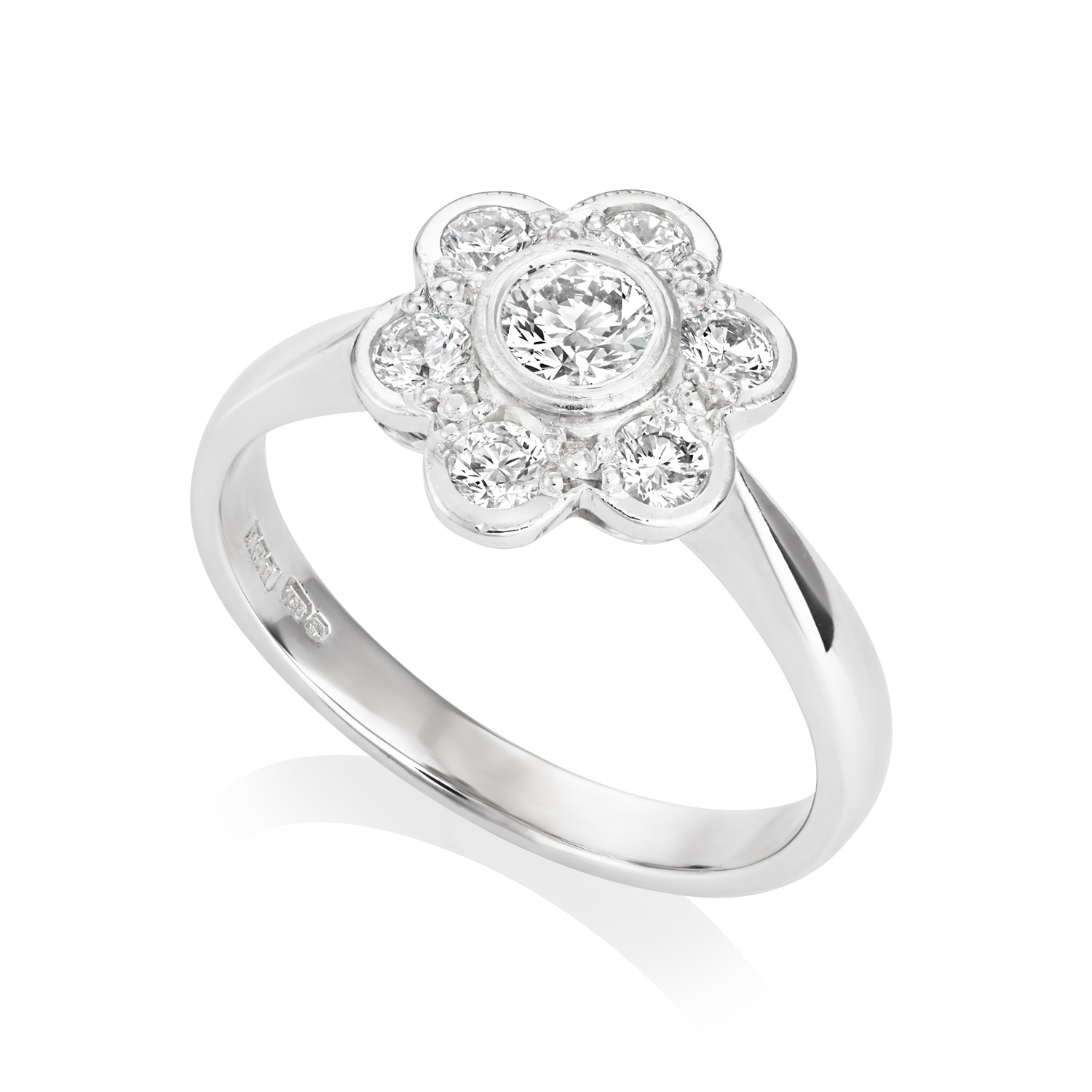 An 18ct white gold diamond flower cluster ring with rub over settings, containing seven stones.