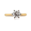 An 18ct yellow and white gold round brilliant cut diamond set solitaire ring with a cornet setting.