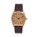 A vintage Rolex, Oyster Perpetual with a 34mm 18ct yellow gold case with a brown lizard strap with an 18ct yellow gold buckle, featuring a fluted bezel and a textured champagne coloured dial.