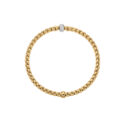 An 18ct yellow gold Flex'It bracelet with a single 18ct white gold diamond set rondel belonging to FOPE's EKA Collection.