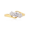 An 18ct yellow and white gold round brilliant cut diamond three stone ring. Hallmarked Birmingham 2011.