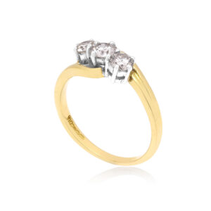 An 18ct yellow and white gold round brilliant cut diamond three stone ring. Hallmarked Birmingham 2011.