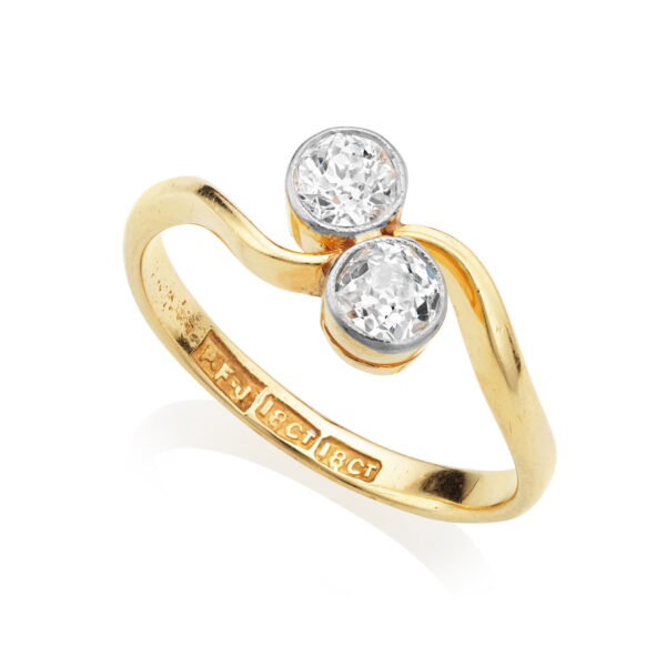 An 18ct yellow gold and platinum old brilliant cut two stone diamond crossover ring.