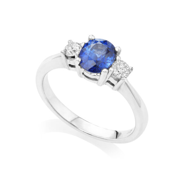 An 18ct white gold oval sapphire and brilliant cut diamond three stone ring.