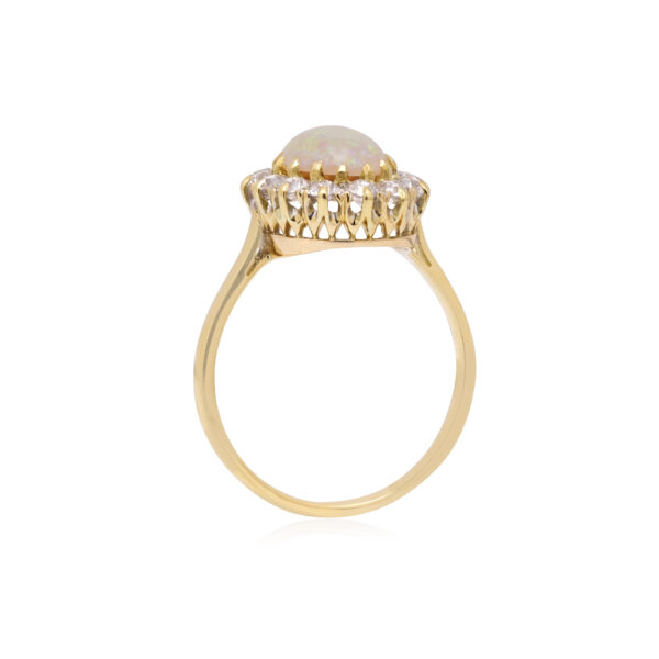 An antique oval shaped opal and old brilliant cut diamond cluster ring.