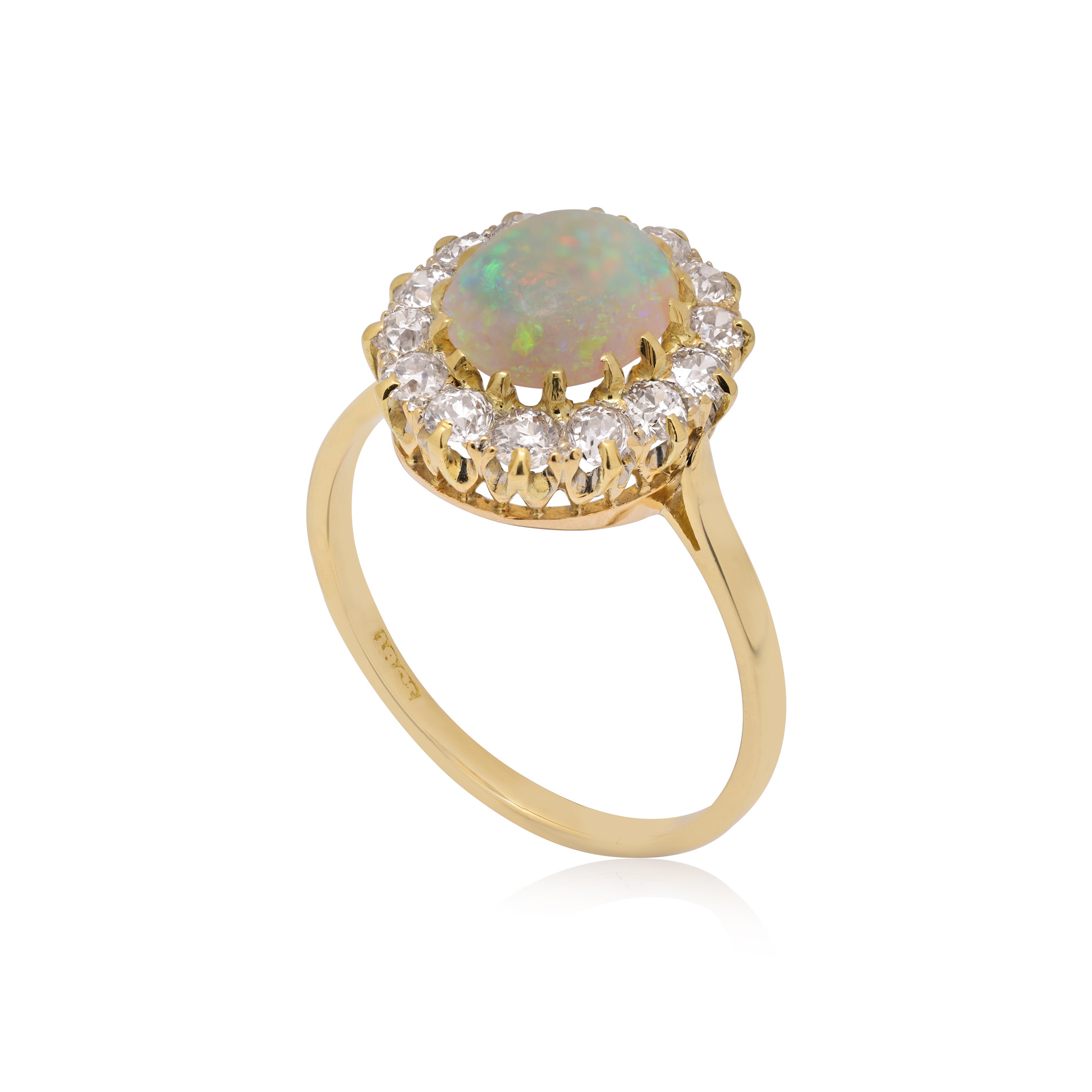 An antique oval shaped opal and old brilliant cut diamond cluster ring.