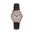 A vintage Tudor watch with a 30mm 9ct yellow gold case with a black leather strap featuring a white dial.
