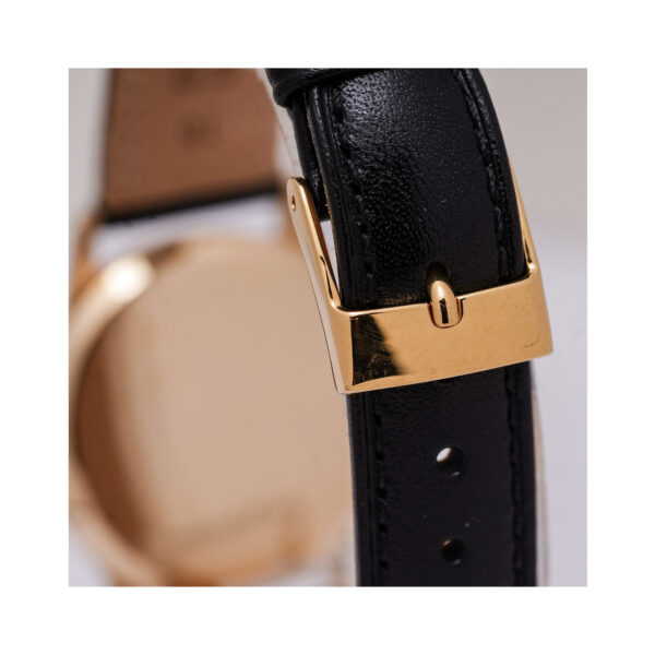 A vintage Tudor watch with a 30mm 9ct yellow gold case with a black leather strap featuring a white dial.