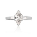 An 18ct white gold marquite and brilliant cut diamond solitaire ring with tapered baguette cut diamond shoulders.