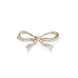 An Edwardian 18ct yellow gold and platinum diamond tied bow brooch set with old cut and rose cut diamonds.