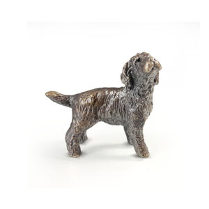 Made from solid foundry bronze, this piece depicts a small Cockapoo dog standing and is designed by sculptor Michael Simpson.