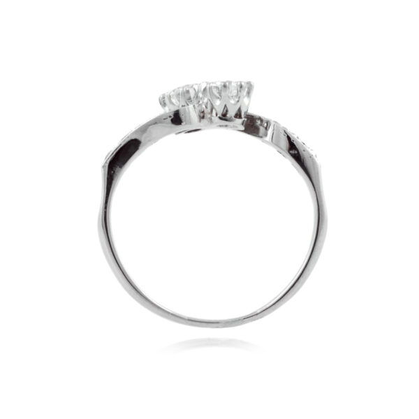 A two stone diamond crossover ring with diamond set shoulders, featuring eight diamonds in total.