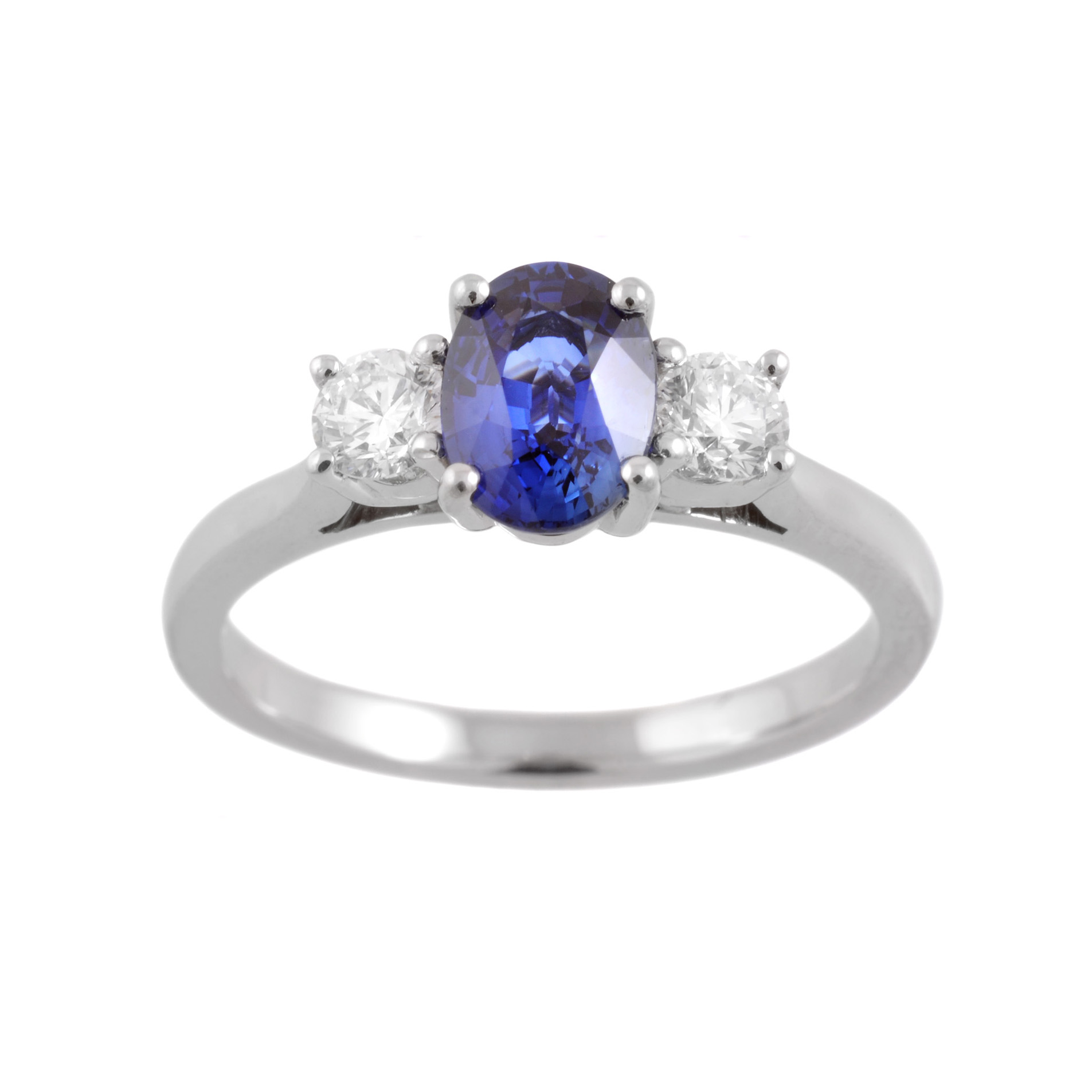 A platinum oval sapphire and round brilliant cut diamond three stone ring.