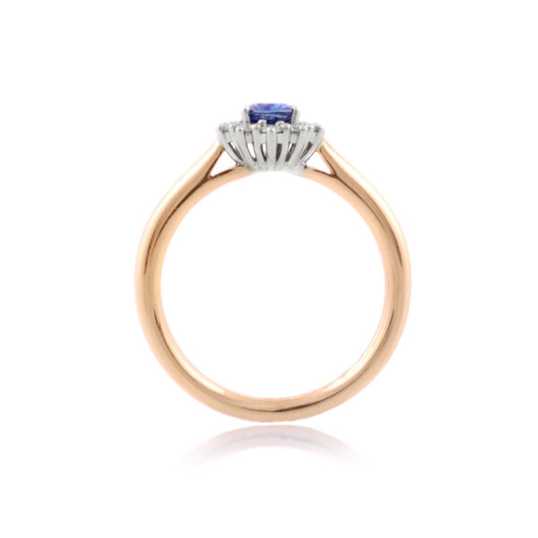 An 18ct gold, oval sapphire and brilliant cut diamond set cluster ring.