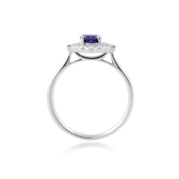 A platinum set fancy cluster ring with a brilliant cut sapphire and brilliant and baguette cut diamonds.