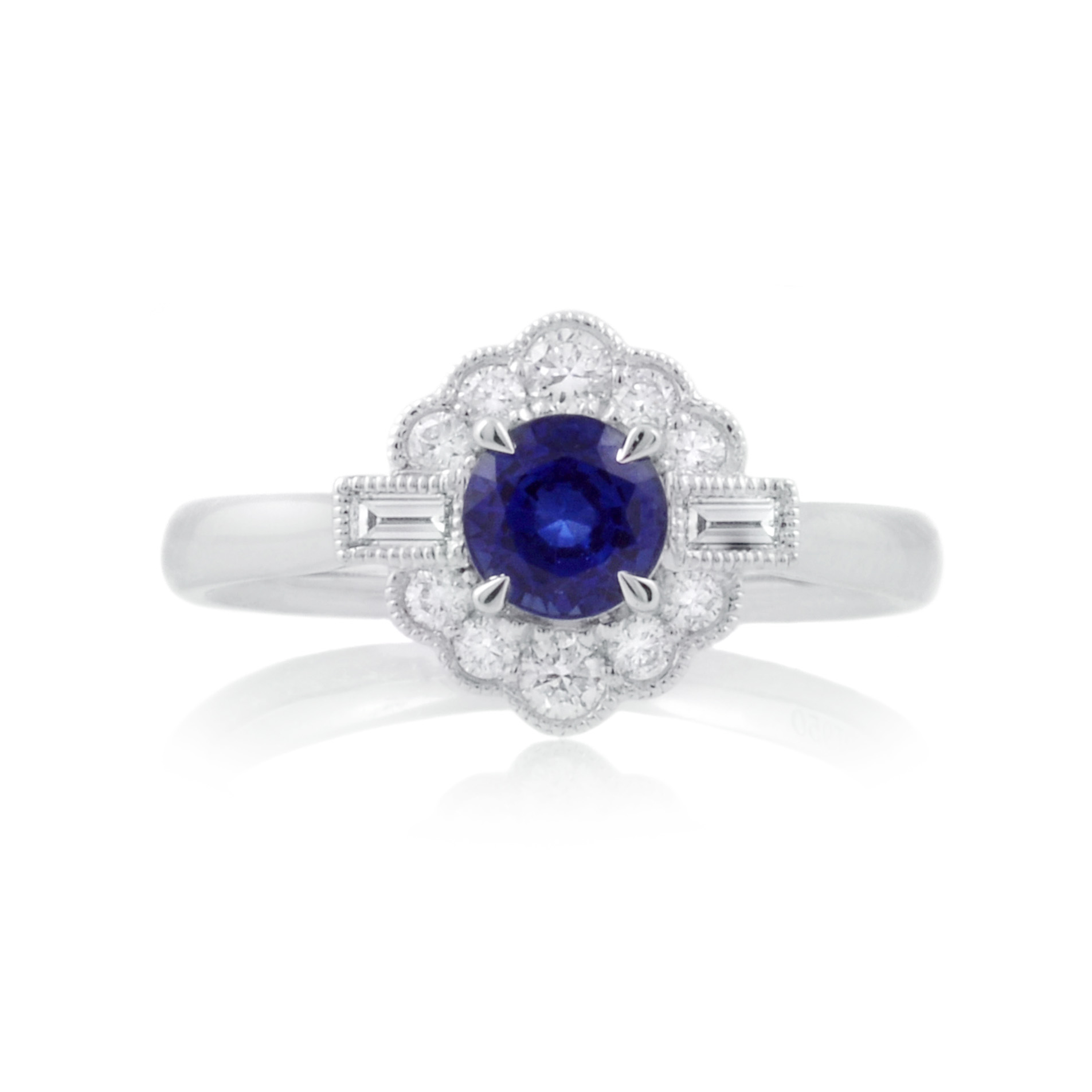 A platinum set fancy cluster ring with a brilliant cut sapphire and brilliant and baguette cut diamonds.