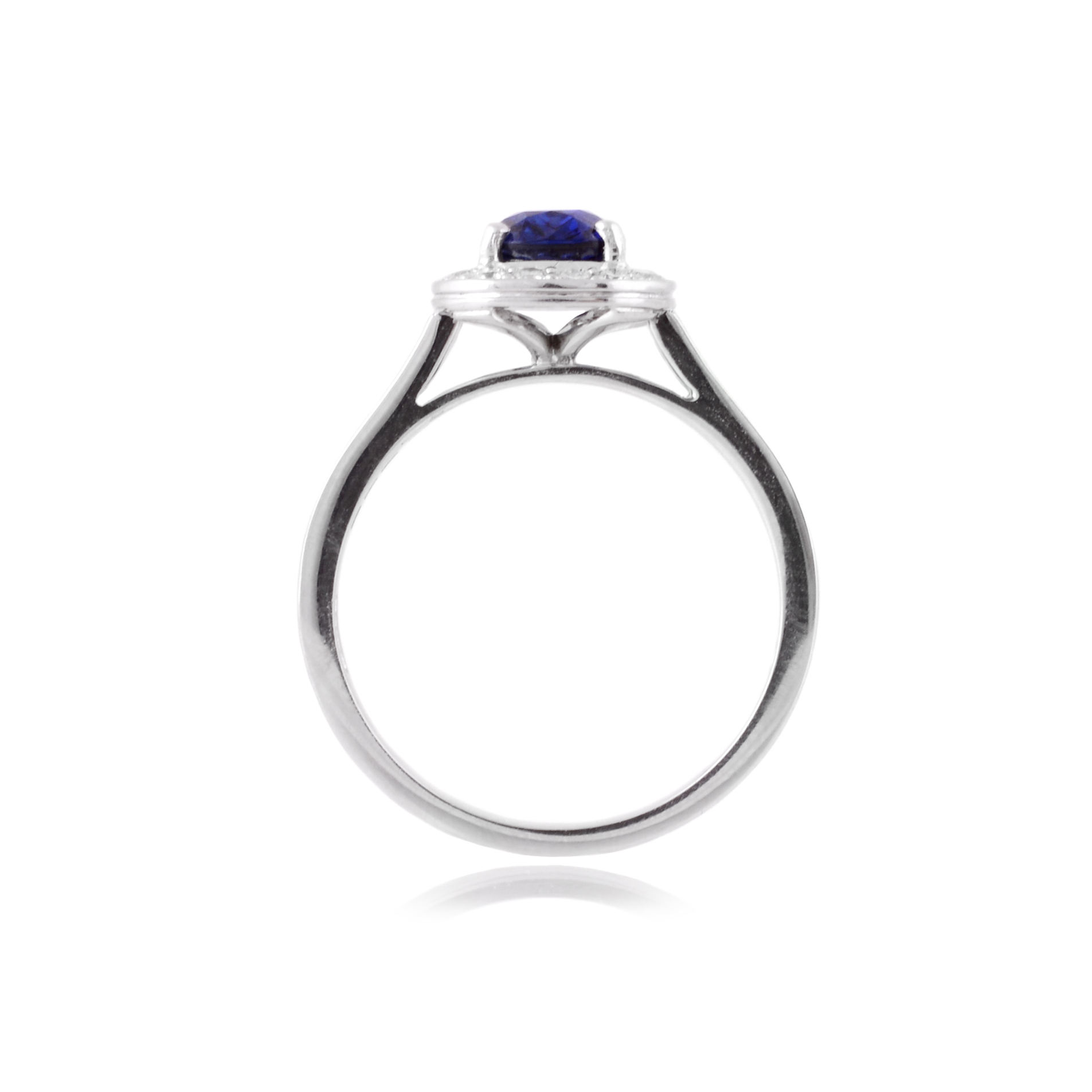 An 18ct white gold, oval shaped sapphire and diamond set cluster ring with diamond set shoulders.