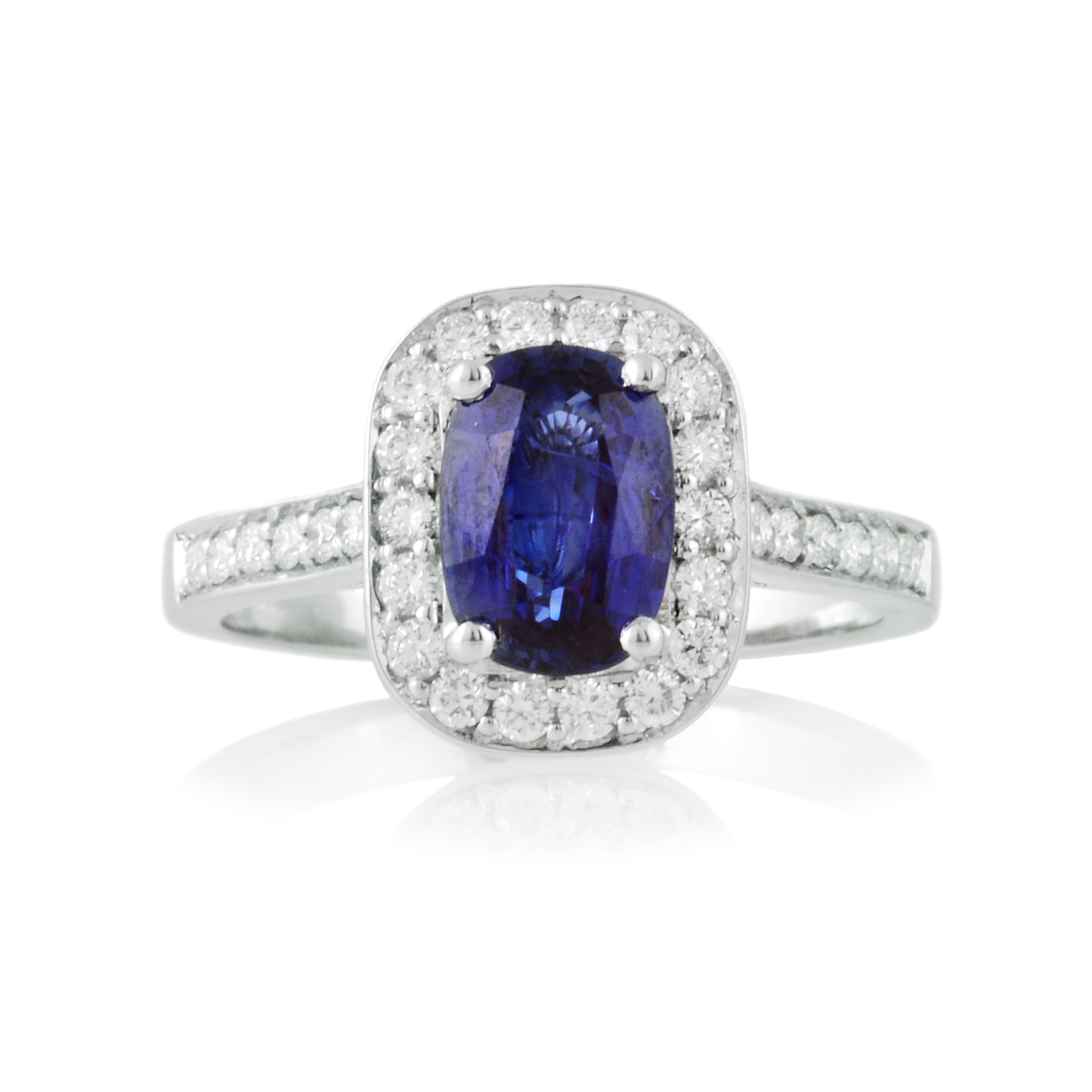 An 18ct white gold, oval shaped sapphire and diamond set cluster ring with diamond set shoulders.