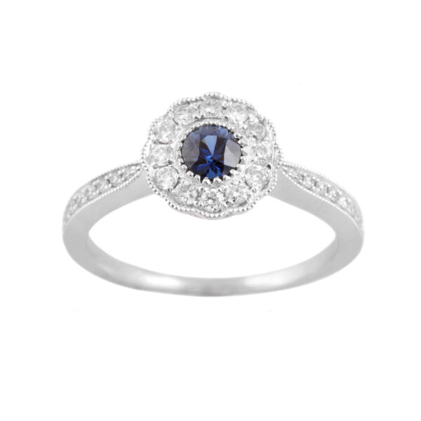 An 18ct white gold, sapphire and diamond set millegrain cluster ring with diamond set shoulders in 18ct white gold.