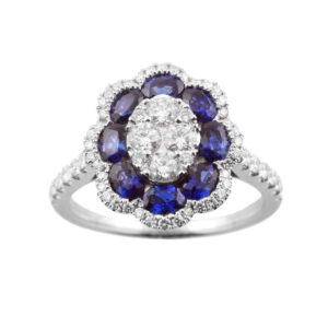 An 18ct white gold oval shaped sapphire and diamond flower cluster ring, with diamond set shoulders.