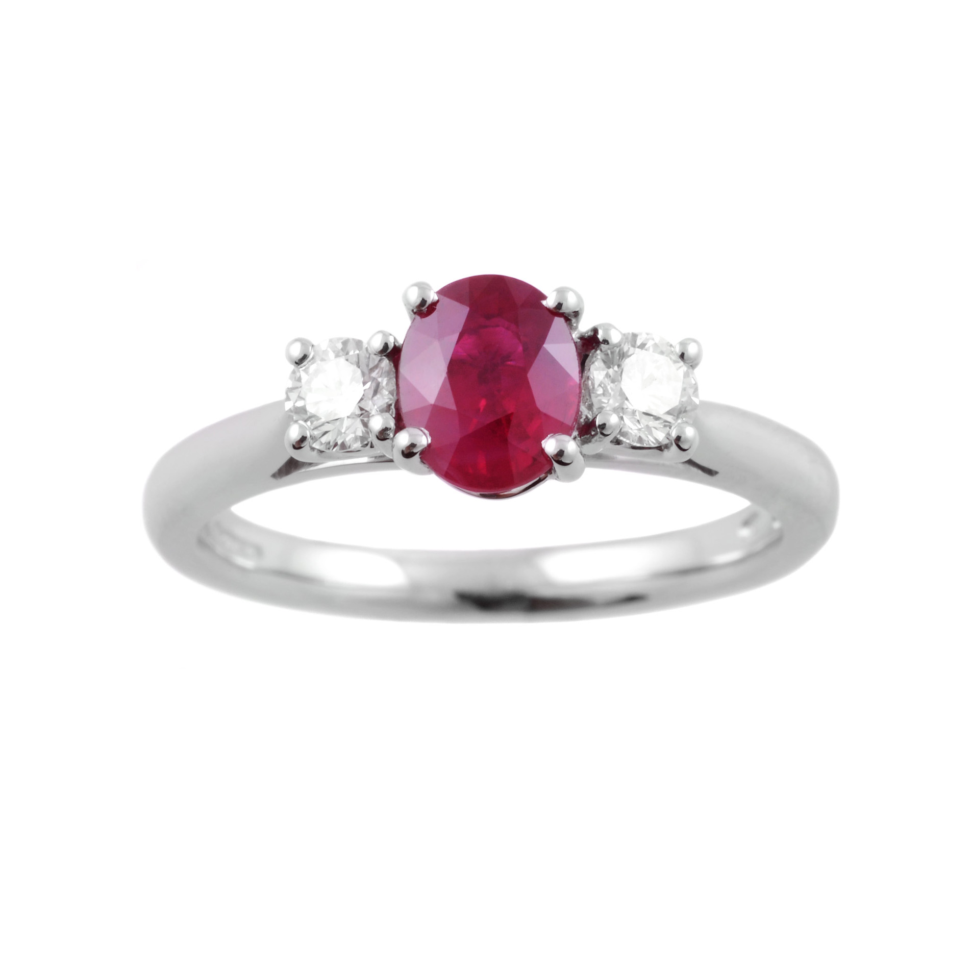 A platinum oval ruby and round brilliant cut diamond claw set three stone ring.