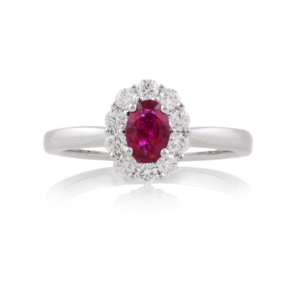 A platinum, oval shaped ruby and brilliant cut diamond set cluster ring.