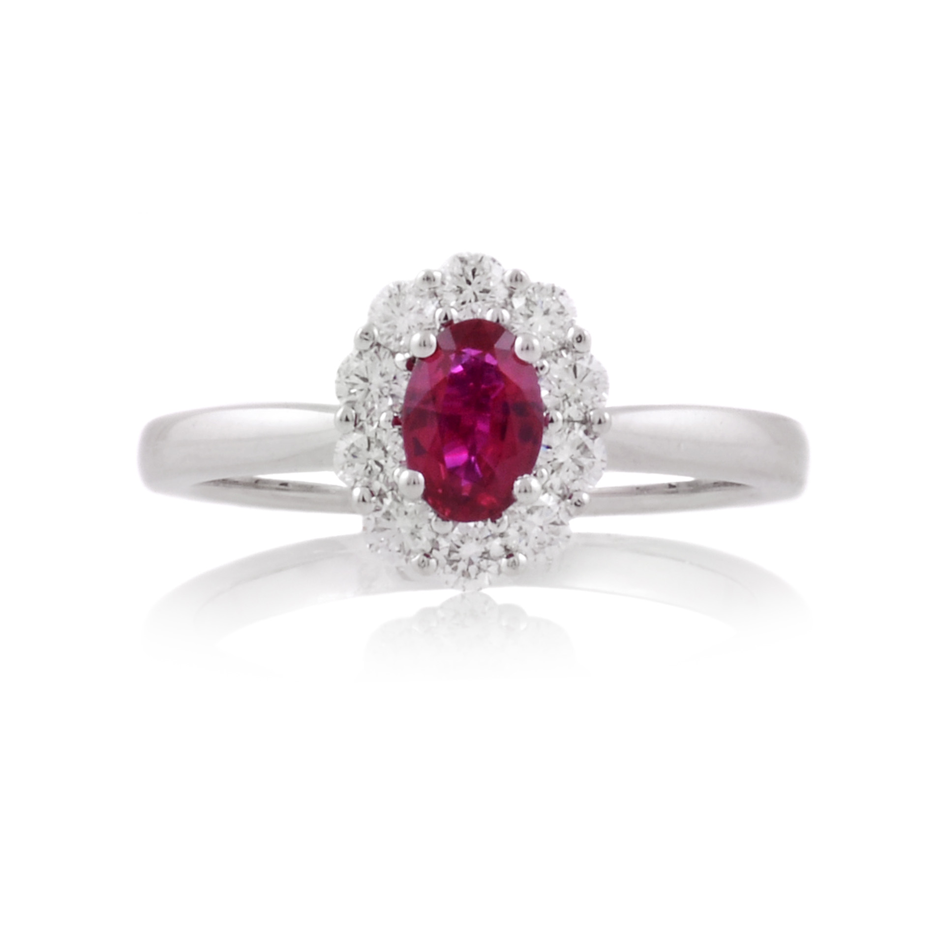 A platinum, oval shaped ruby and brilliant cut diamond set cluster ring.