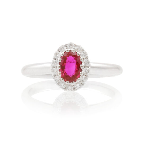 An 18ct white gold, oval ruby and diamond set cluster ring.