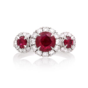 A platinum ruby and brilliant cut diamond set triple cluster ring.