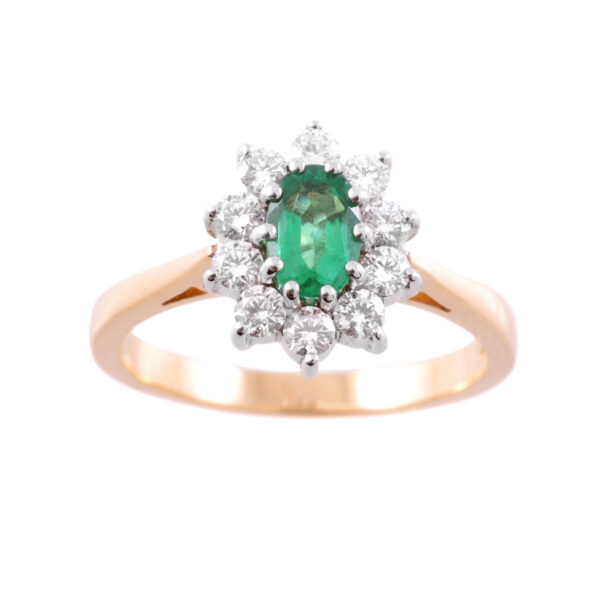 An 18ct yellow and white gold oval emerald and round brilliant cut diamond cluster ring.