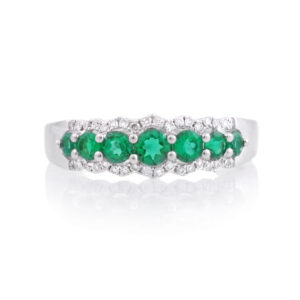An 18ct white gold, emerald and diamond set seven stone fancy ring.