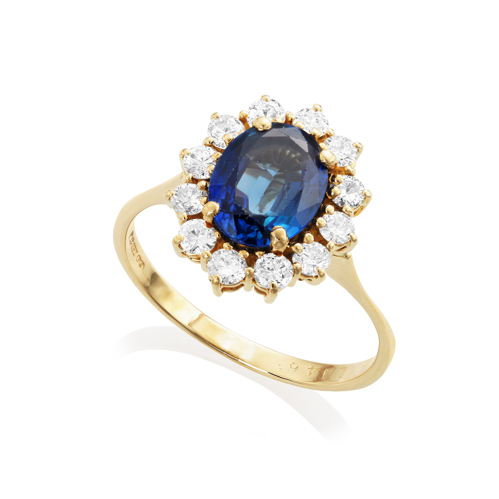 An 18ct yellow and white gold oval shaped sapphire and diamond cluster ring with a claw setting.