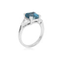 An 18ct white gold square cut aquamarine and brilliant cut diamond three stone ring, with brilliant cut diamonds set to the shoulders.