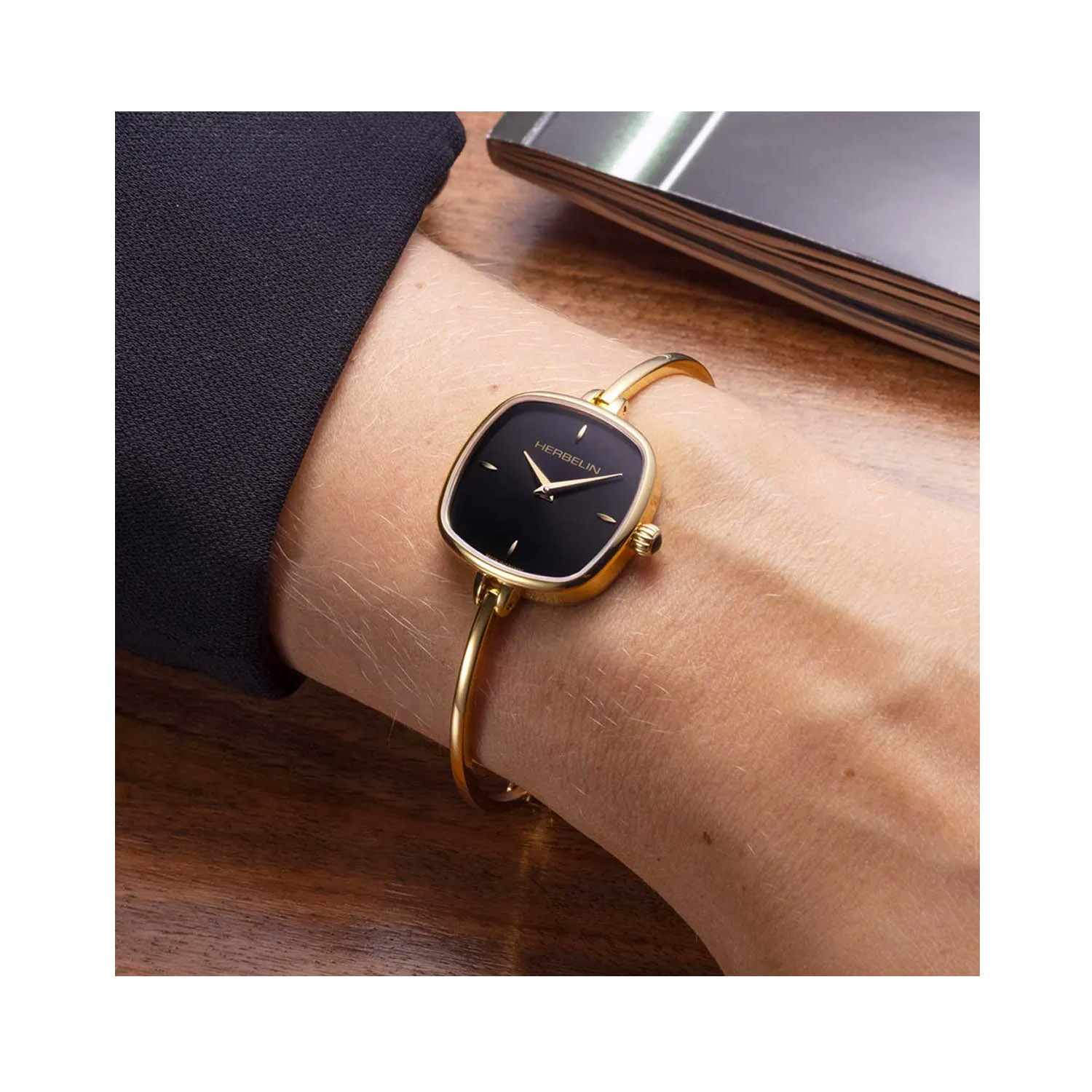 Herbelin, Fil with a 24mm square yellow gold PVD coated stainless steel case and bracelet strap featuring a black dial.