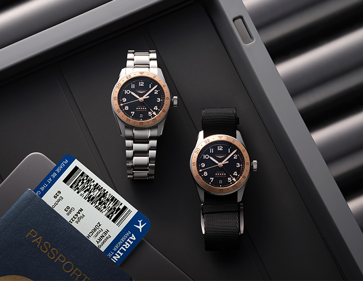 Two Longines Spirit watches laid on a table, one with a stainless steel strap and the other with a black strap.