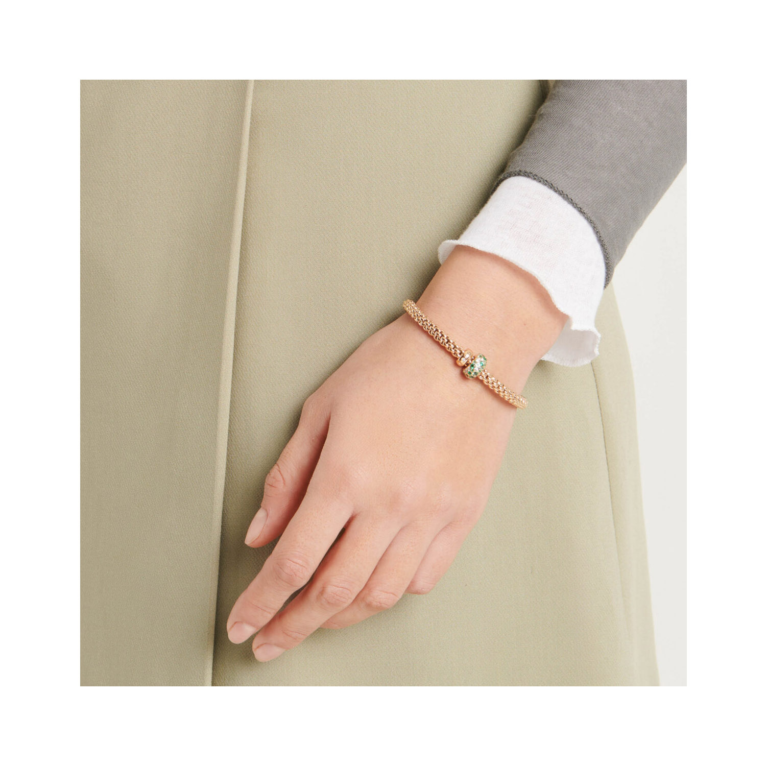 An 18ct yellow gold Flex'It bracelet with an emerald and diamond rondel and a polished diamond set rondel, belonging to FOPE's Solo collection.