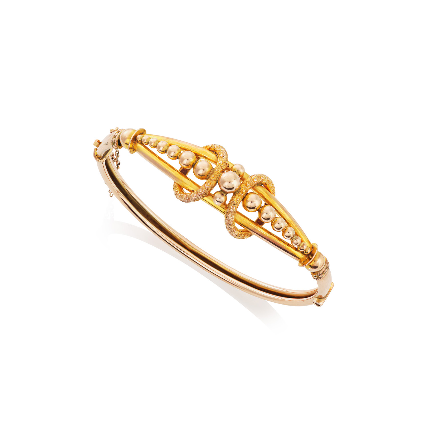 A late Victorian 9ct yellow gold hinged bangle of bifurcated form decorated with graduated beads and applied chased hoops. Circa 1890.