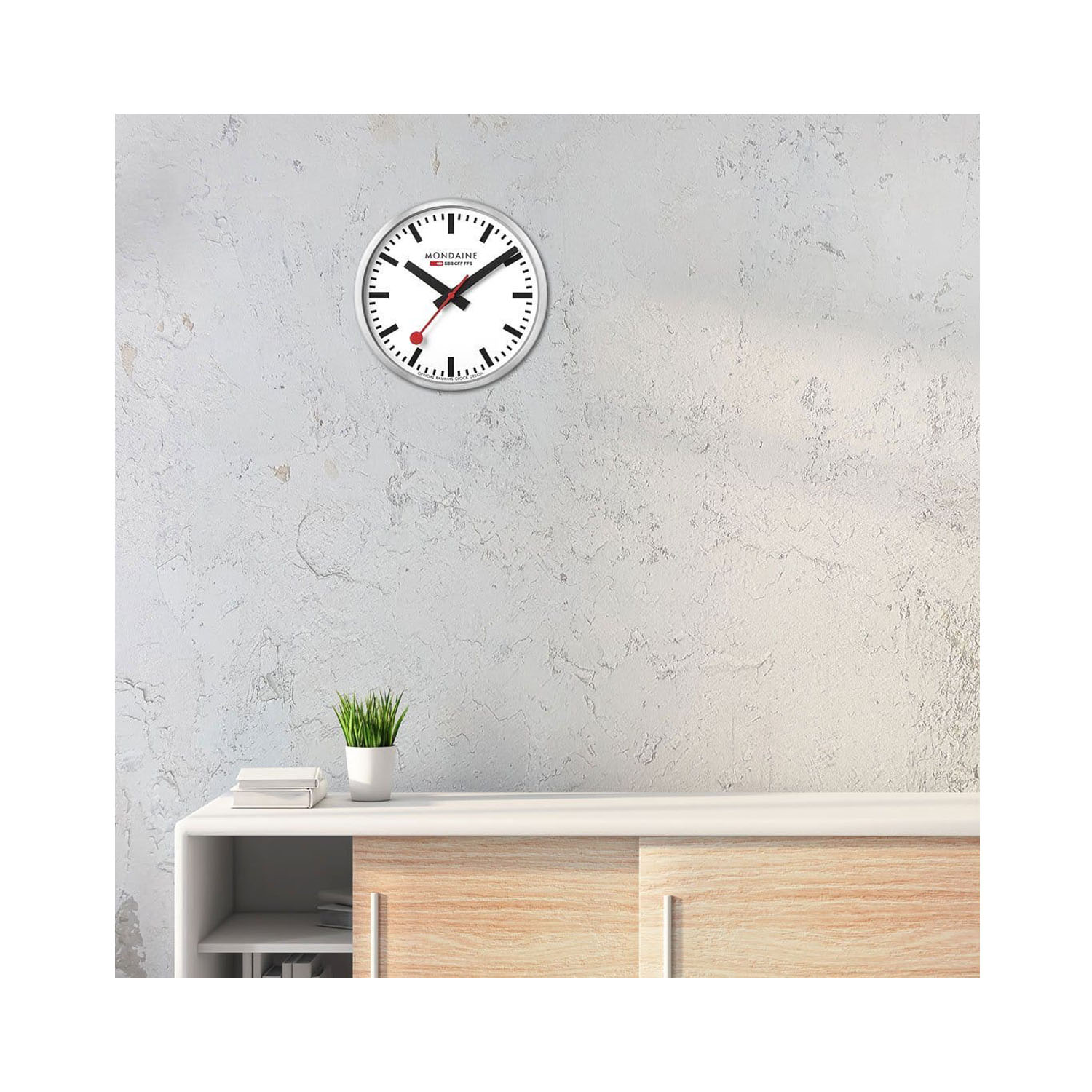 Mondaine, Silver Coloured Wall Clock Mondaine, Silver Coloured Wall Clock with a 40cm diameter aluminium case with a quartz battery featuring a three hand white face.