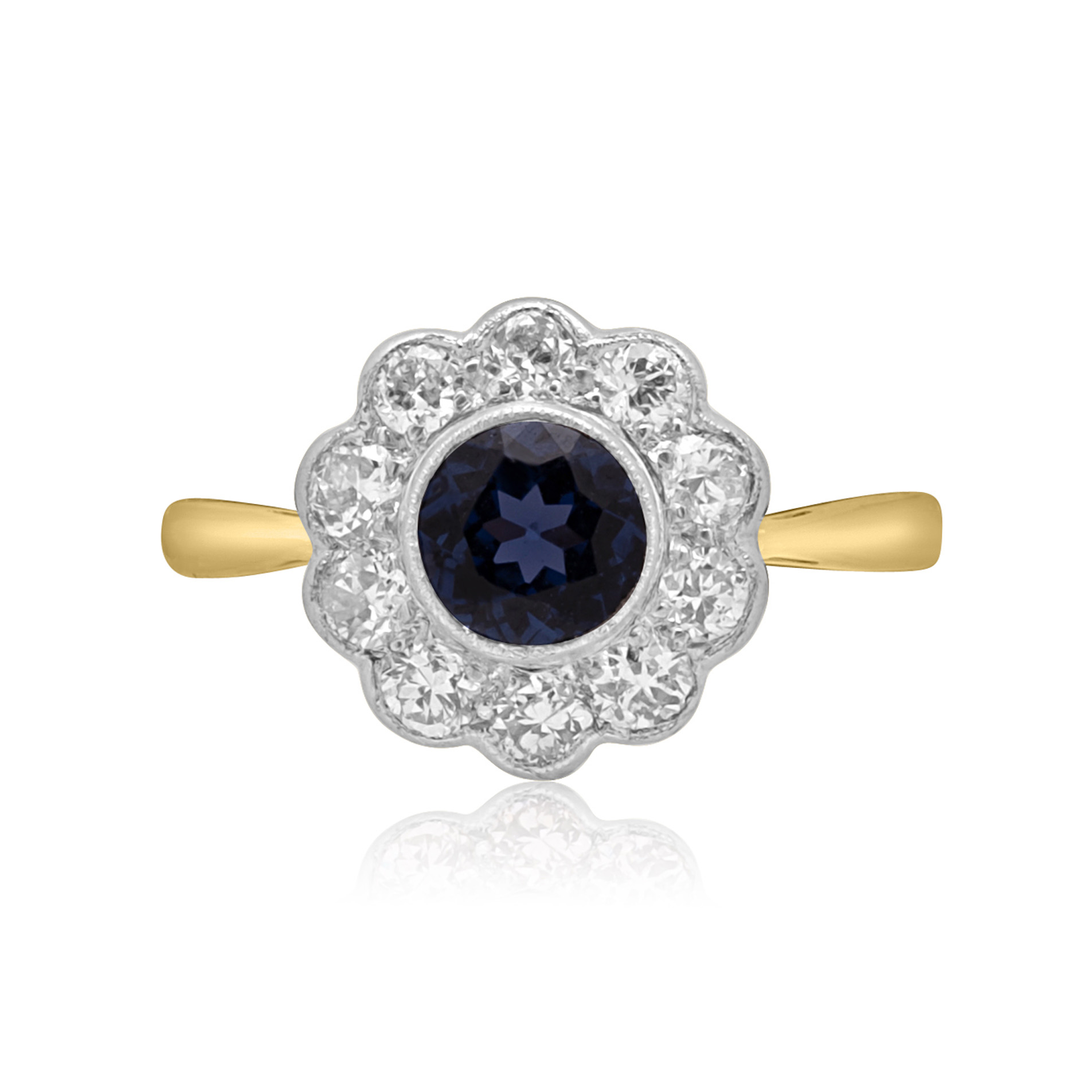 Vintage Sapphire & Diamond Flower Cluster Ring A mid 20th century sapphire and diamond flower cluster ring. The round faceted millegrain set sapphire is surrounded by ten old brilliant cut diamonds.