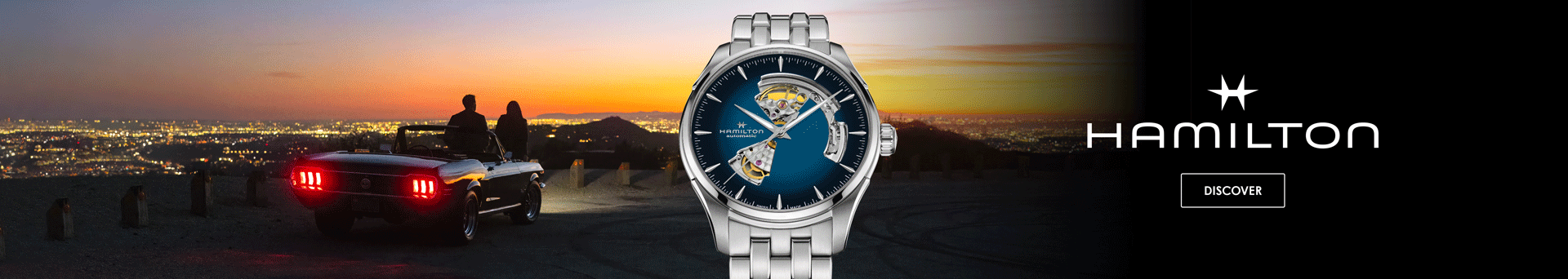 A Hamilton, Jazzmaster watch with a blue open heart dial set against an evening skyline.