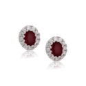 A pair of 18ct white gold oval shaped ruby and round brilliant cut diamond set cluster stud earrings, with a post and butterfly fastening for pierced ears.