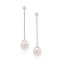 A pair of 9ct white gold freshwater pearl earrings with a single rubover set diamond, with a post and butterfly fastening for pierced ears.