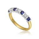 An 18ct yellow and white gold seven stone sapphire and round brilliant cut diamond bar set half eternity ring.