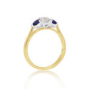 An 18ct yellow and white gold pear shaped sapphire and round brilliant cut diamond three stone ring.