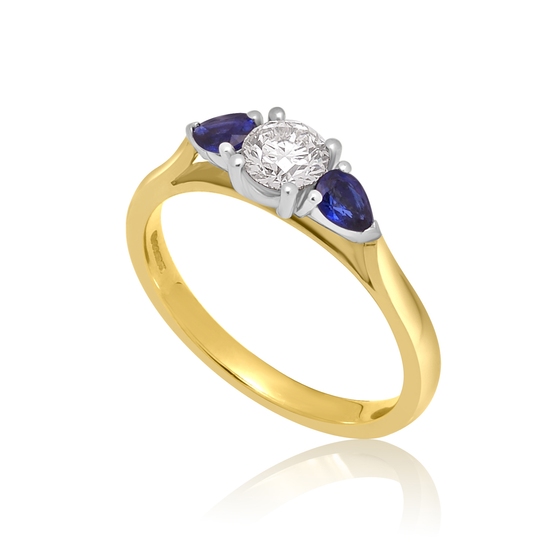 An 18ct yellow and white gold pear shaped sapphire and round brilliant cut diamond three stone ring.