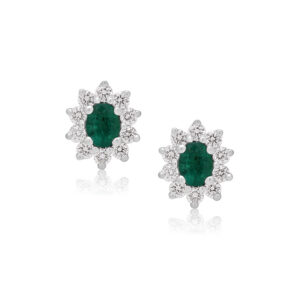 A pair of 18ct white gold oval shaped emerald and round brilliant cut diamond stud earrings, with a post and butterfly clip fastening for pierced ears.